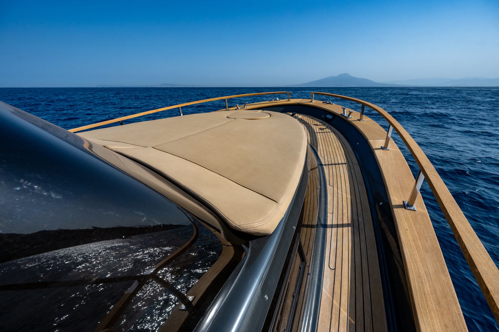 La prua in teak col Vesuvio all'orizzonte