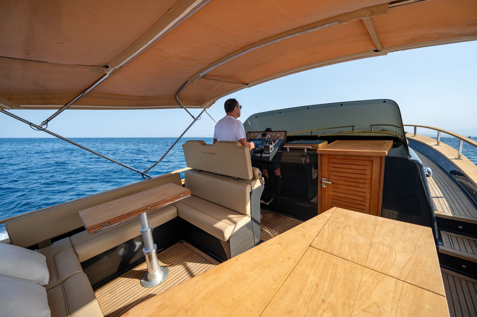 La dinette in teak, lo skipper alla guida
